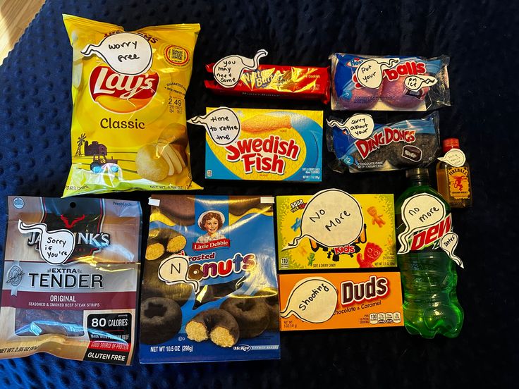 several snacks are laid out on a blanket with one bag of chips and two bags of doughnuts