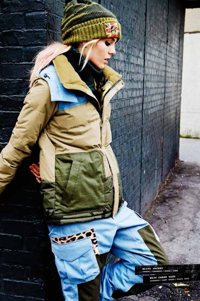 a woman leaning against a brick wall with her hand on her hip