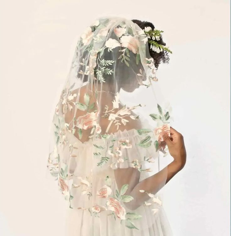 a woman wearing a veil with flowers on it