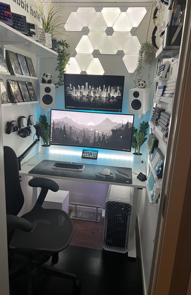 a computer desk with a monitor, keyboard and speakers on it in a home office