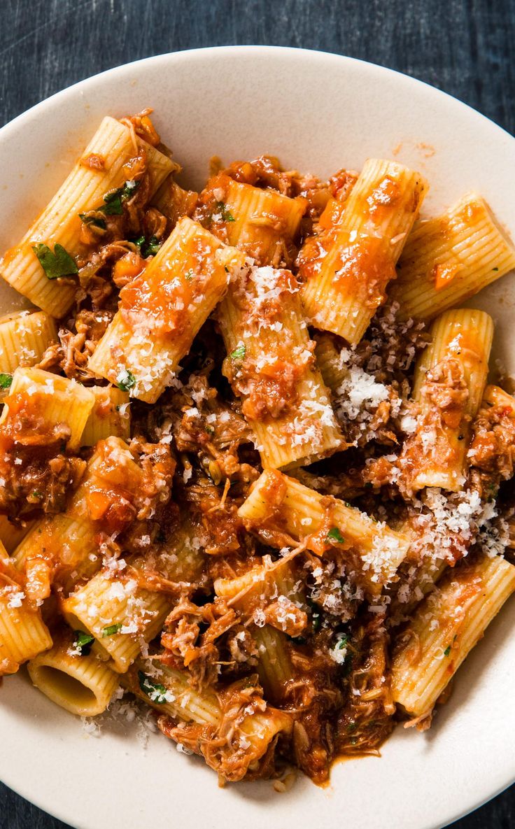 pasta with meat sauce and parmesan cheese in a white bowl