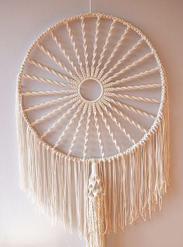 a white dream catcher hanging on the wall