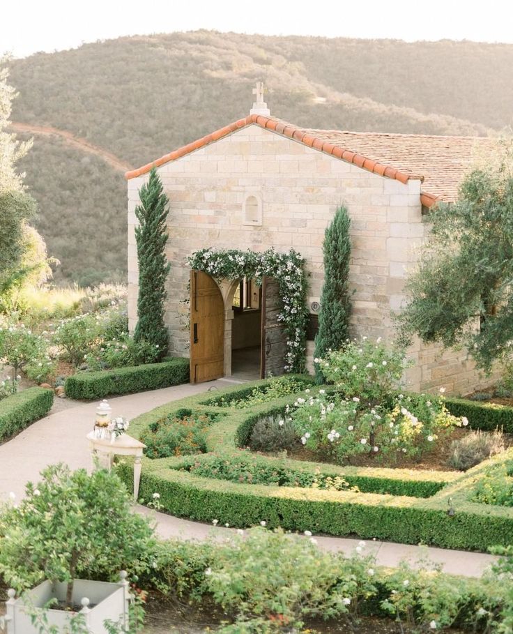 an outdoor wedding venue with hedges and flowers