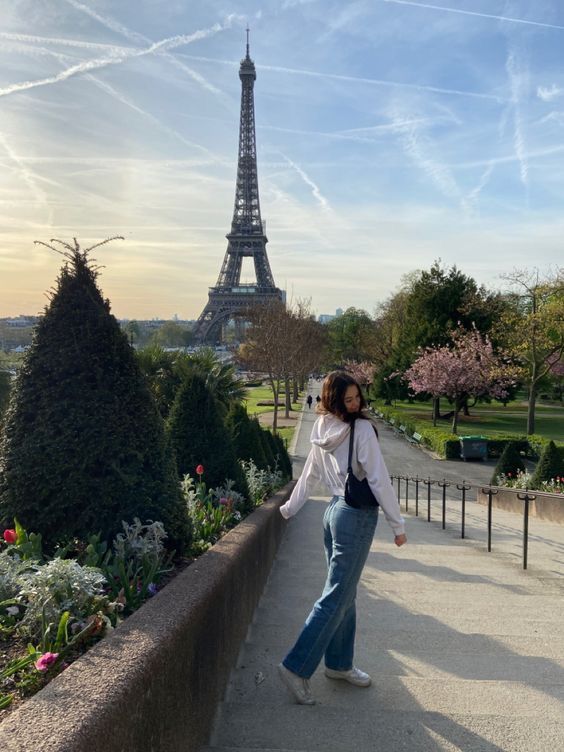 a woman standing in front of the eiffel tower