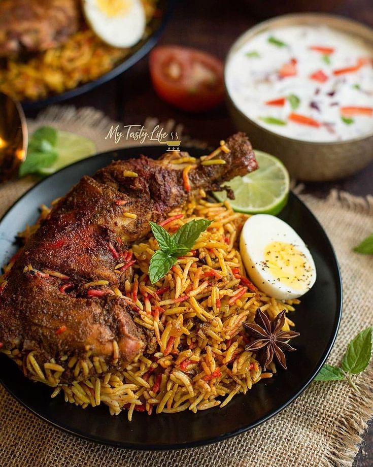 a black plate topped with rice and meat