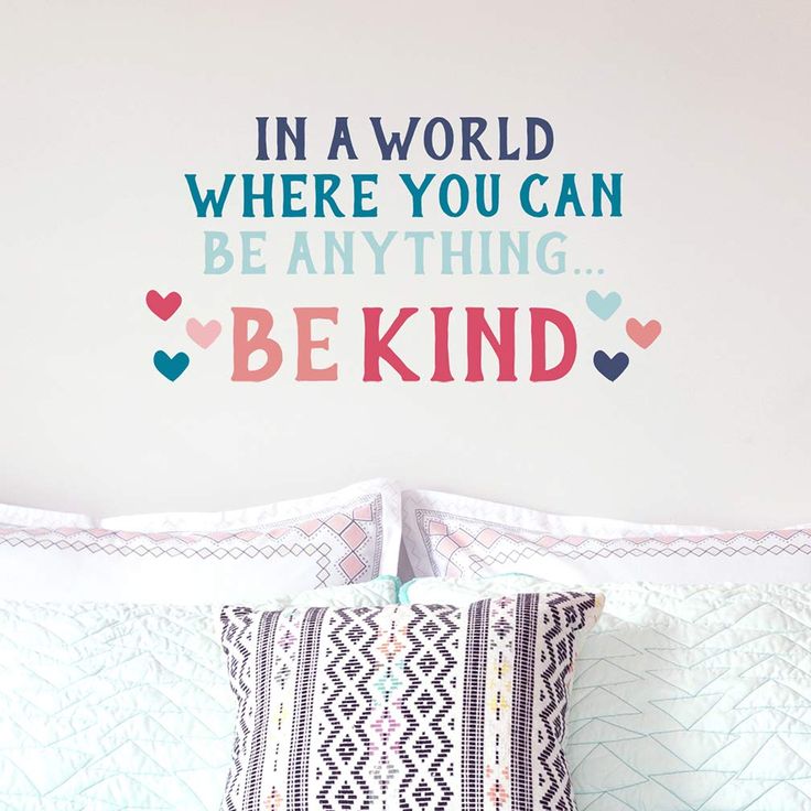 a bedroom with a wall decal that says in a world where you can be anything be kind