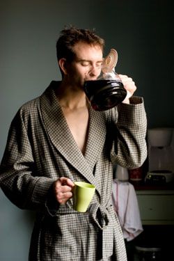 a man in a robe drinking from a cup