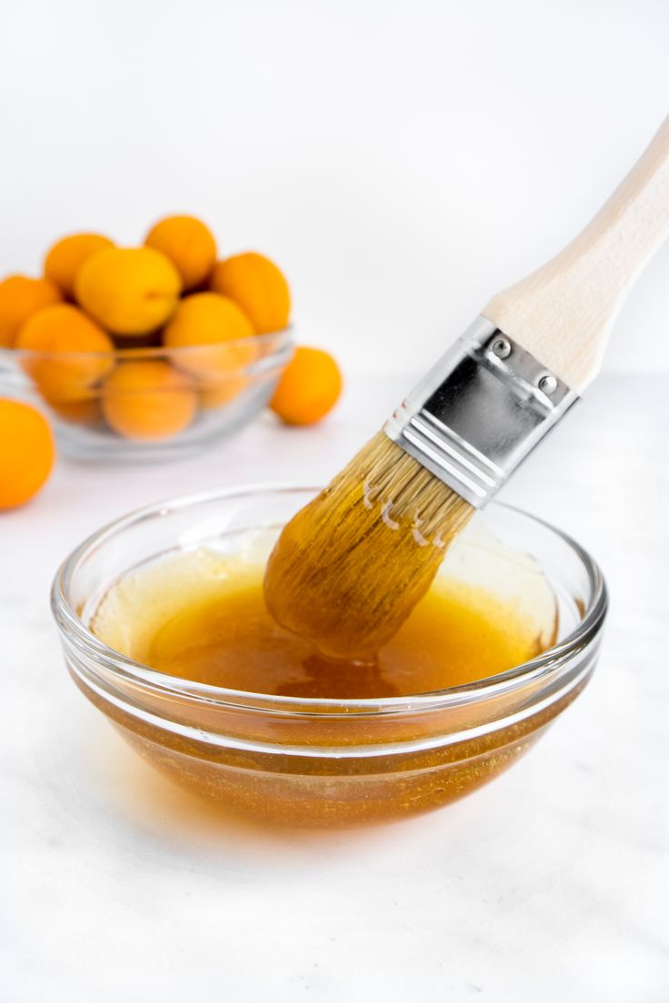 a bowl filled with oranges next to a brush