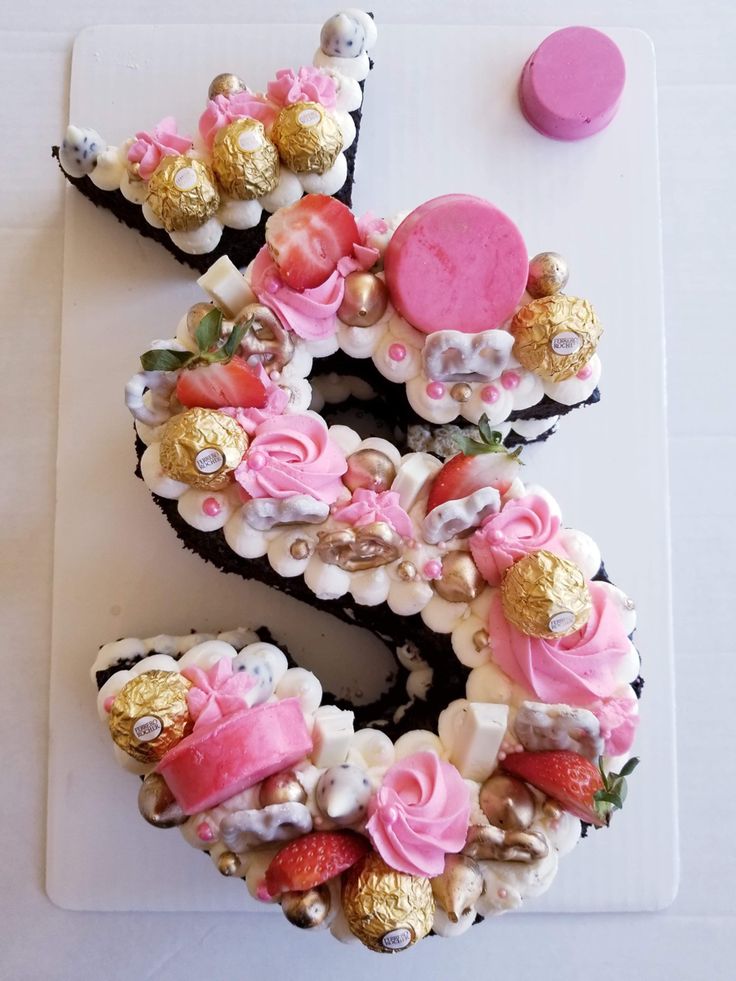 a number shaped cake with pink and gold decorations