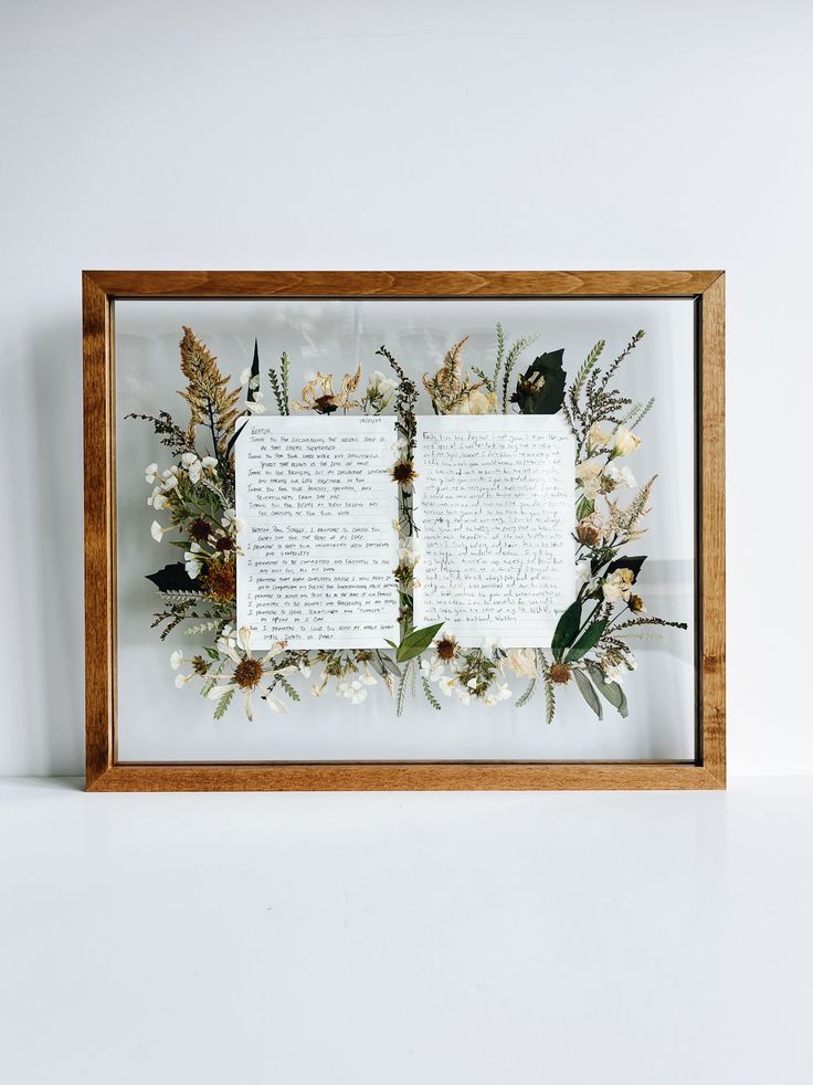 a framed book with flowers and leaves on it