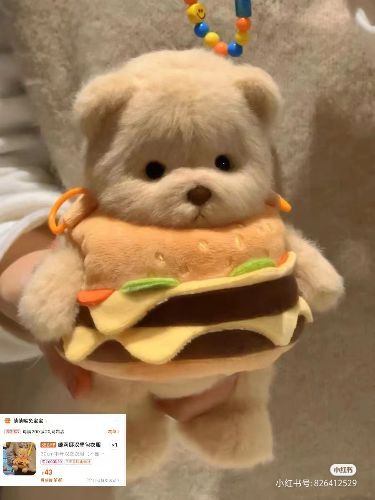 a person holding a stuffed teddy bear with a large sandwich on it's chest