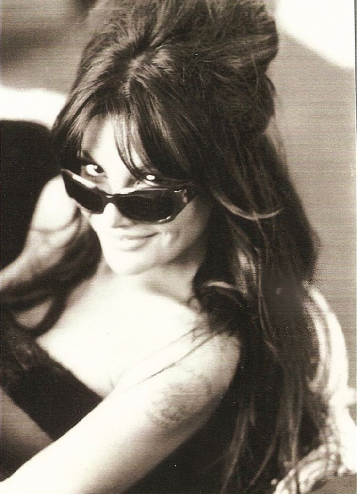 black and white photograph of a woman wearing sunglasses with long hair in the middle of her face