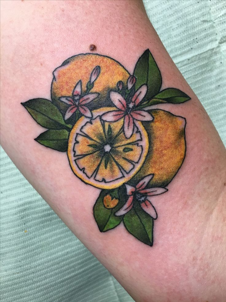 an orange with leaves and flowers on the arm