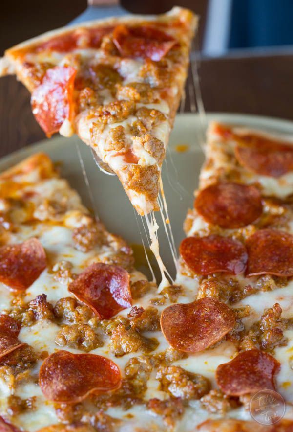 a slice of pepperoni pizza being lifted with a fork