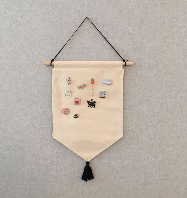 a white wall hanging with buttons and tassels on it's back end