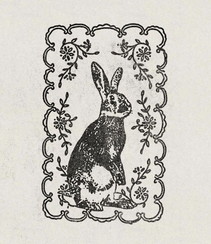 a black and white drawing of a rabbit in a frame with floral border around it