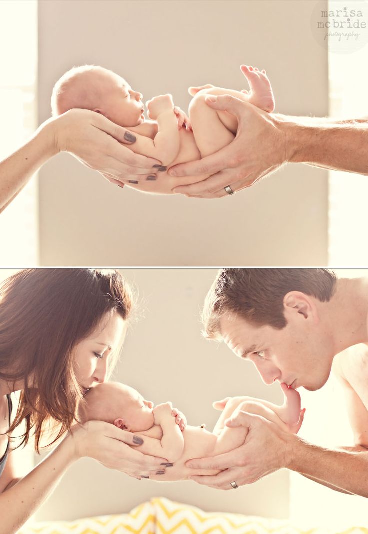 a man and woman holding a baby in their hands