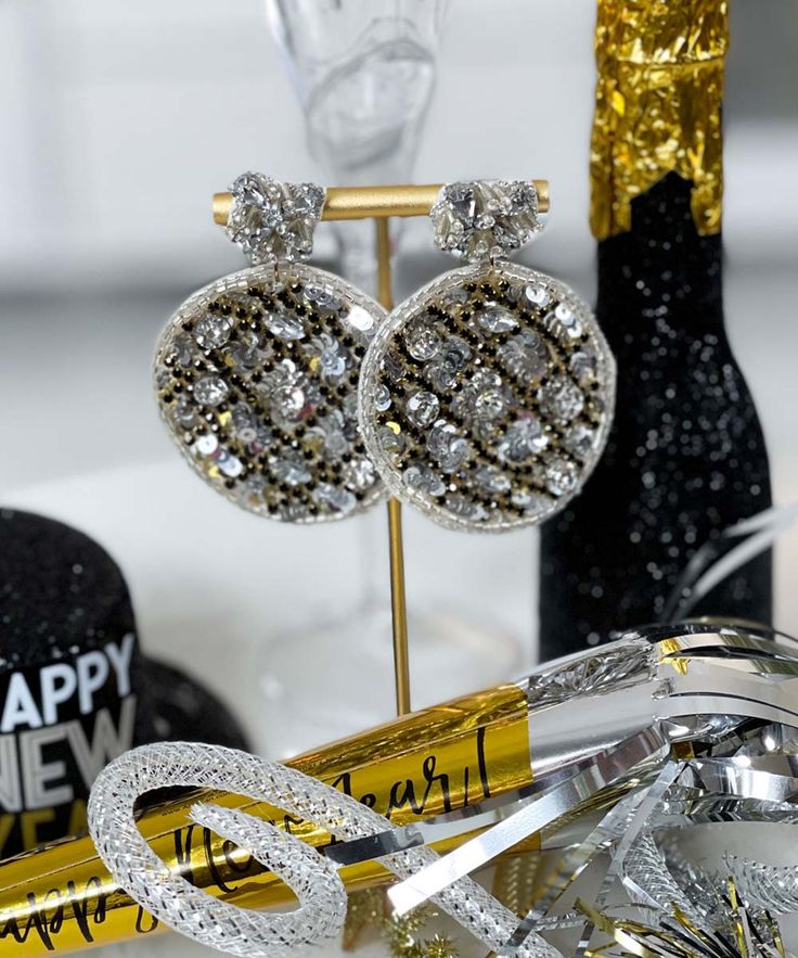 Introducing our "Ball Drop Earrings" in stunning silver – the perfect accessory to bring a touch of glamour to your New Year's Eve ensemble. These earrings feature a 2-tier design with new year's disco ball beaded embroidery, creating a dazzling and celebratory look.
Crafted with intricate details, including crystal rhinestones, sequins, seed beads, and beaded embroidery, these earrings capture the festive spirit of New Year's celebration. With a height of 2.75" and a width of 2", they make a bold statement, adding sparkle and elegance to your overall look.
Celebrate the countdown to the new year with style and sophistication by adorning these "Ball Drop Earrings" in silver. Handcrafted and handmade, these earrings are a unique and eye-catching addition to your festive wardrobe, ensu Elegant Metal Clip-on Earrings For Party, Glamorous Rhinestone Earrings For Gifts, Silver Dazzling Crystal Earrings With Bling, Dazzling Silver Crystal Earrings With Bling, Glamorous Sparkling Earrings As Gift, Glamorous Sparkling Earrings For Gift, Glamorous Silver Sparkling Crystal Earrings, Glamorous Crystal Clip-on Earrings For Party, Sparkling Round Jewelry For Evening