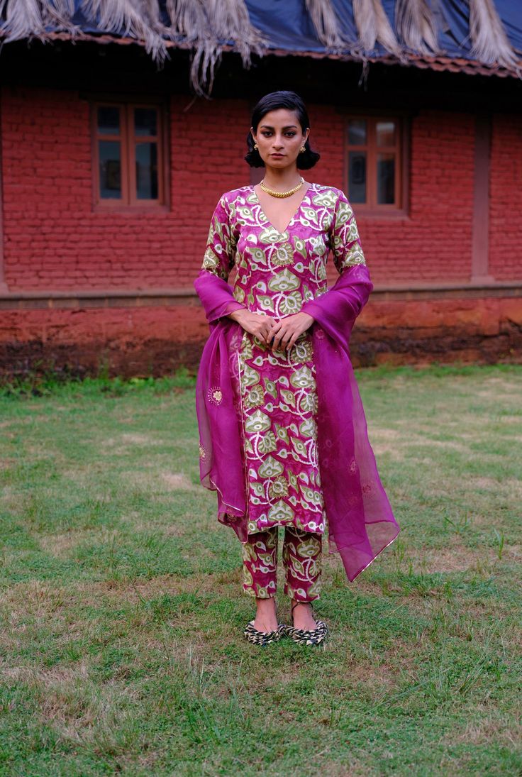 We love a classic, this kurta set returns in a new, vivid print. Crafted in lustrous silk, this kurta set features a V neckline with tailored, cropped trousers. The bold print is hand embroidered to add grandeur. Pair it with our lightweight, sheer organza dupatta dyed in jewelled violet, decorated with intricate zari thread work and beading. We believe customers have a right to know how their product was made. 5.5 meters of Mashru silk sourced from Gujarat has been used for this piece. Hand-block printed in Jaipur. Hand embroidered and manufactured at our workshop in Pune, India. This product is crafted in Jaipur, India using the traditional artisan technique of hand-block printing, and is hand embroidered by our skilled artisans in Pune. Subtle variations in patterns are natural to this Eid Palazzo Set With Printed Motifs, Eid Palazzo Set With Printed Motifs And Straight Pants, Festive Kurta With Zari Work, Festive Kurta With Zari Work And Straight Pants, Eid Bollywood Salwar Kameez With Straight Pants, Eid Salwar Kameez With Zari Work And Straight Pants, Bollywood Style Salwar Kameez For Eid With Straight Pants, Eid Zari Work Salwar Kameez With Straight Pants, Bollywood Style Designer Salwar Kameez With Straight Pants