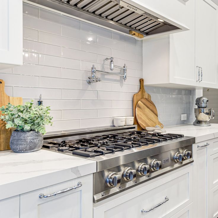 a stove top oven sitting inside of a kitchen next to wooden cutting boards and utensils