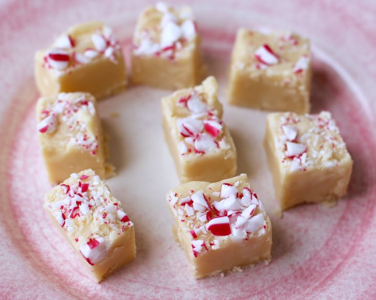 several pieces of cake on a plate with white and red sprinkled toppings