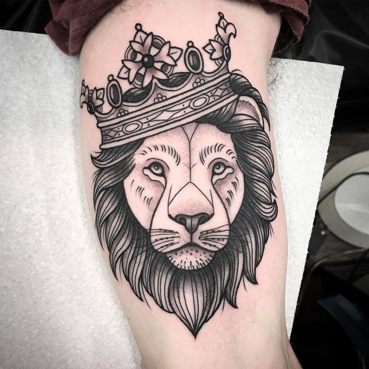 a lion with a crown on his head tattoo by the talented artist mark strick