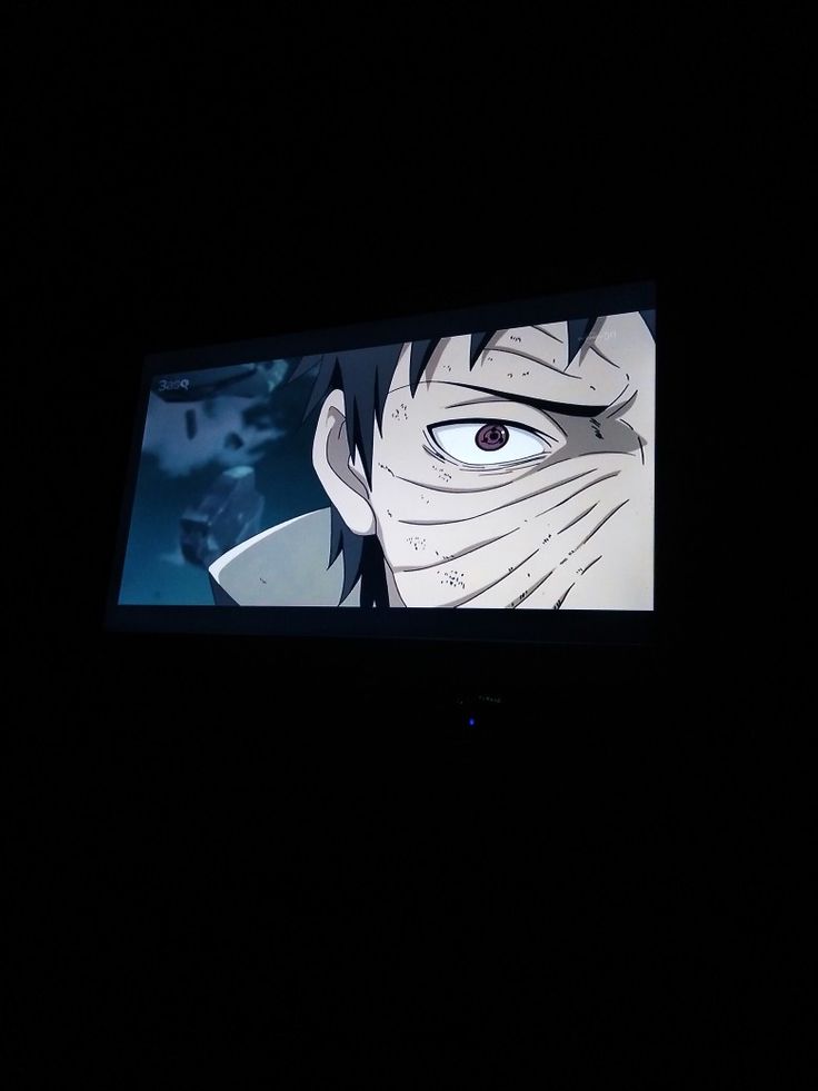 an anime scene is projected on the screen in the dark, with only one eye visible