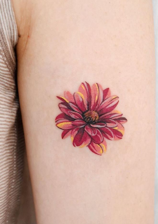 a woman's arm with a red and yellow flower tattoo on the left side