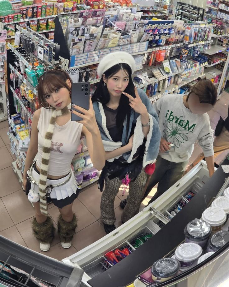 three girls are standing in front of a mirror at a convenience store looking into the camera