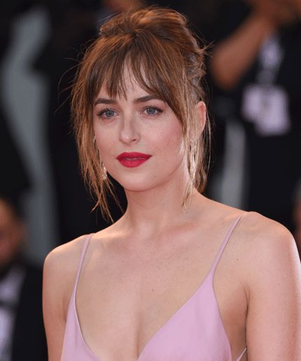 a woman in a pink dress with red lipstick on her face and wearing large earrings