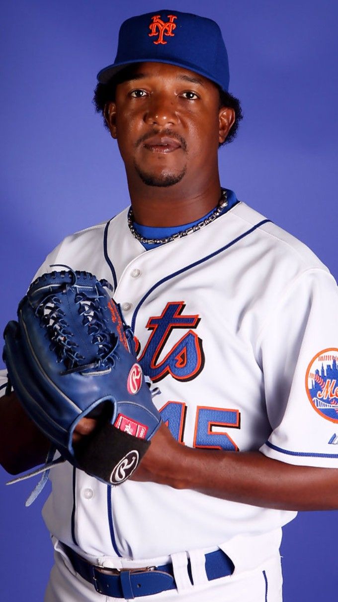 a baseball player is posing for a photo with his glove in hand and wearing a hat