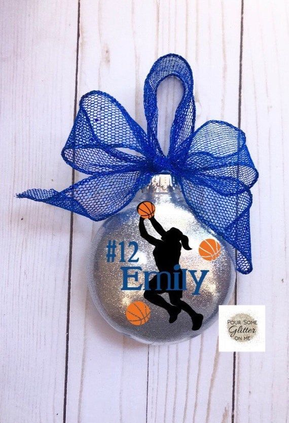 a christmas ornament with a basketball player on it and a blue bow hanging from the front