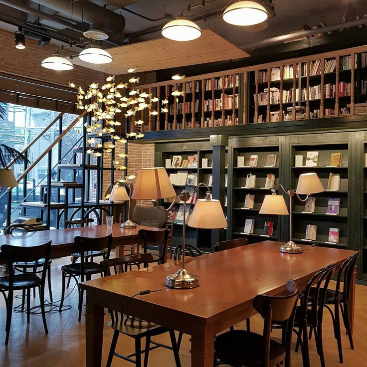 an empty library with tables and chairs in front of large bookshelves filled with books