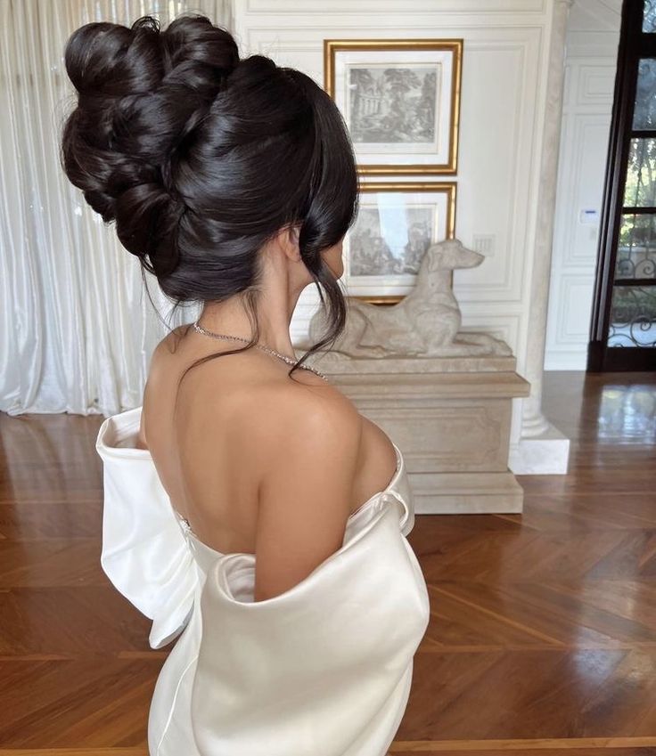 the back of a woman's head wearing a white dress in a living room