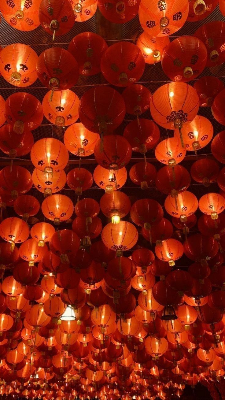 many orange lanterns are hanging from the ceiling