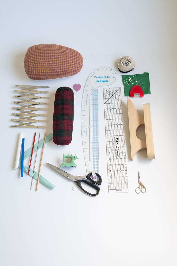 sewing supplies laid out on a white surface with scissors, pins and other crafting items