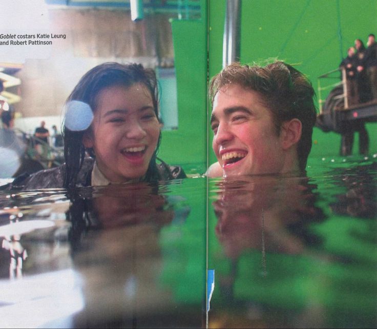 a man and woman are smiling in the water while looking at each other with green screen behind them