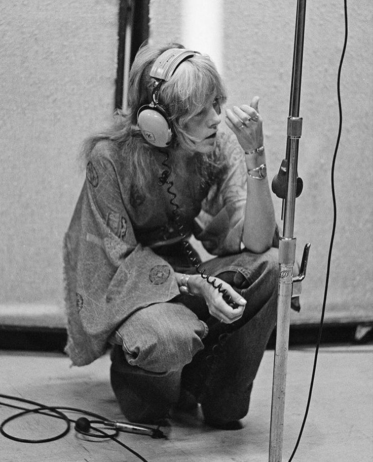 a woman sitting in front of a microphone with headphones on