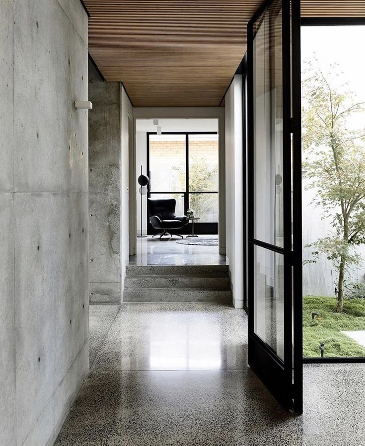 an empty hallway with glass doors leading to the outside