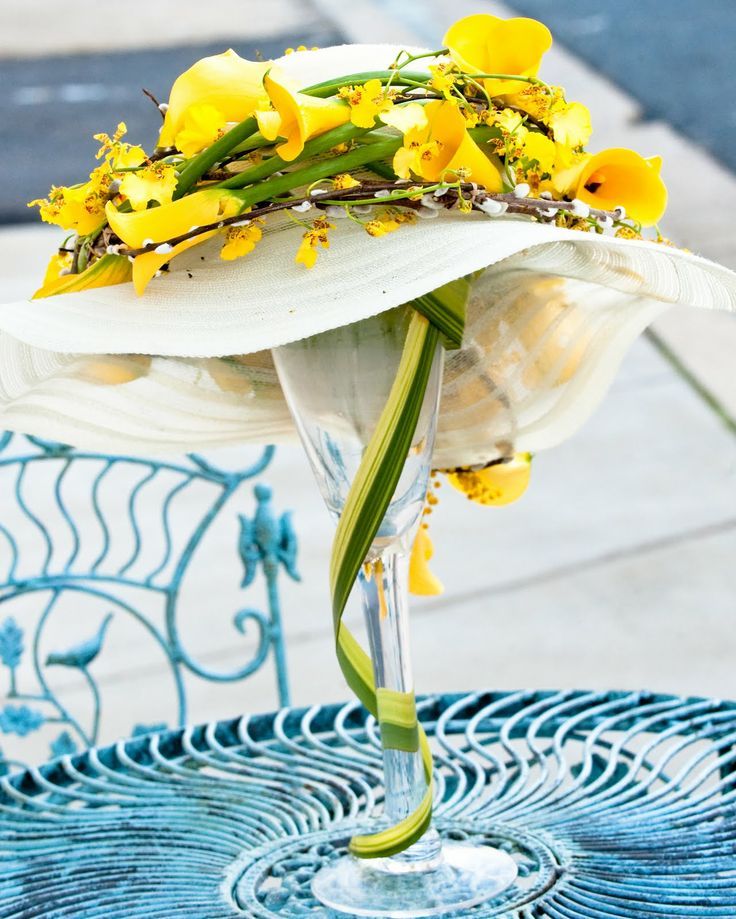 a vase with yellow flowers in it sitting on a blue tablecloth covered patio chair