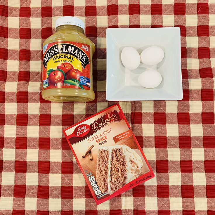 ingredients to make apple cake sitting on a red and white checkerboard tablecloth