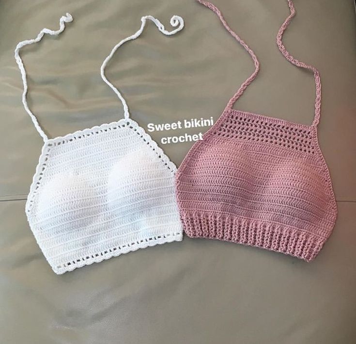 two crocheted bras sitting on top of a bed next to each other