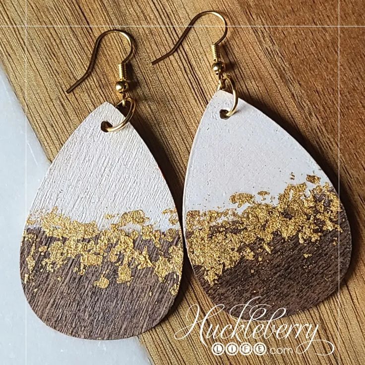 wooden earrings with gold leaf designs on them