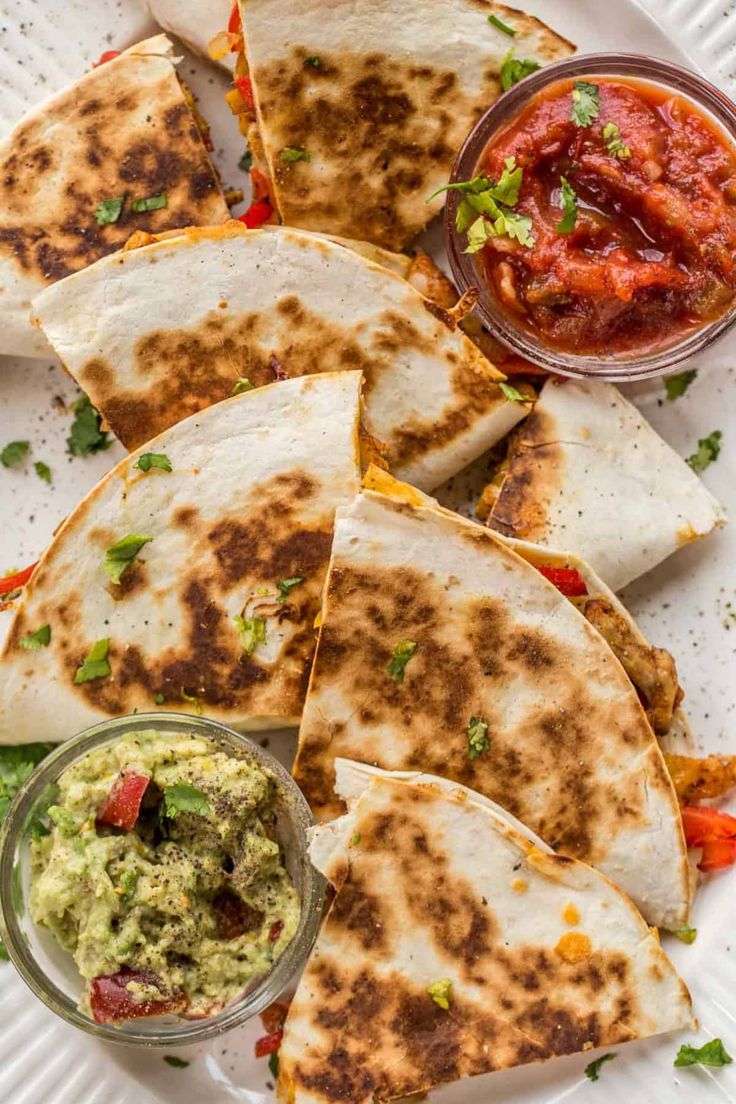 quesadillas on a plate with salsa and guacamole