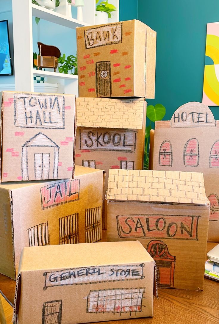 cardboard boxes are stacked on top of each other in front of a blue wall with the words town hall and saloon painted on them