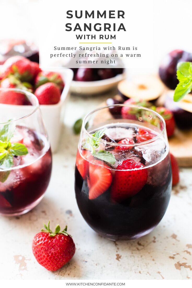 two glasses of sangria with strawberries on the side