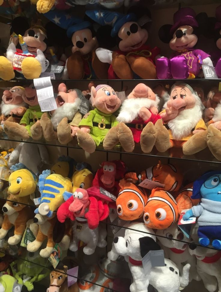 many different stuffed animals are on display in a toy store, including finding nemo and finding dory