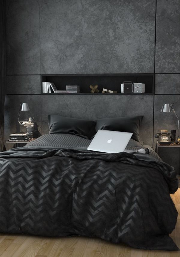 a bedroom with black walls and wooden flooring has a laptop computer on the bed