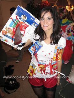 a woman in red shorts and white shirt holding up a box with candy on it