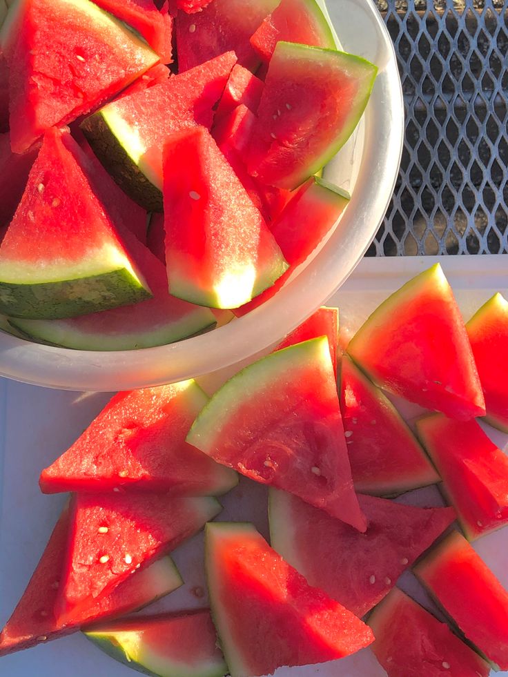 slices of watermelon sit in bowls on a table